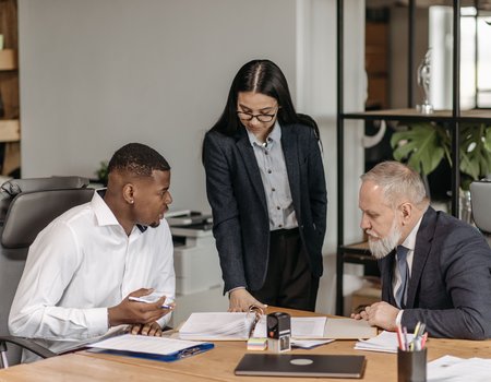 Drei Menschen reden im Büro