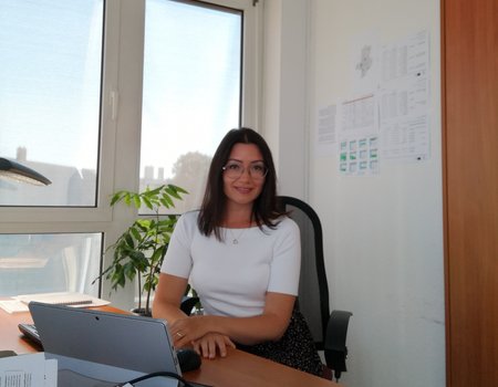 Eine junge Frau sitzt in ihrem Büro am Schreibtisch.