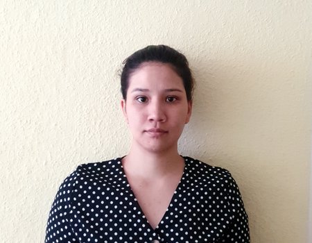 Eine junge Frau steht vor einer weißen Wand