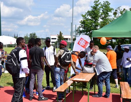 Vor einem Faltpavillon stehen viele Fußballer, um sich für die Teilnahme am Interkulturellen Fußballturnier anzumelden.