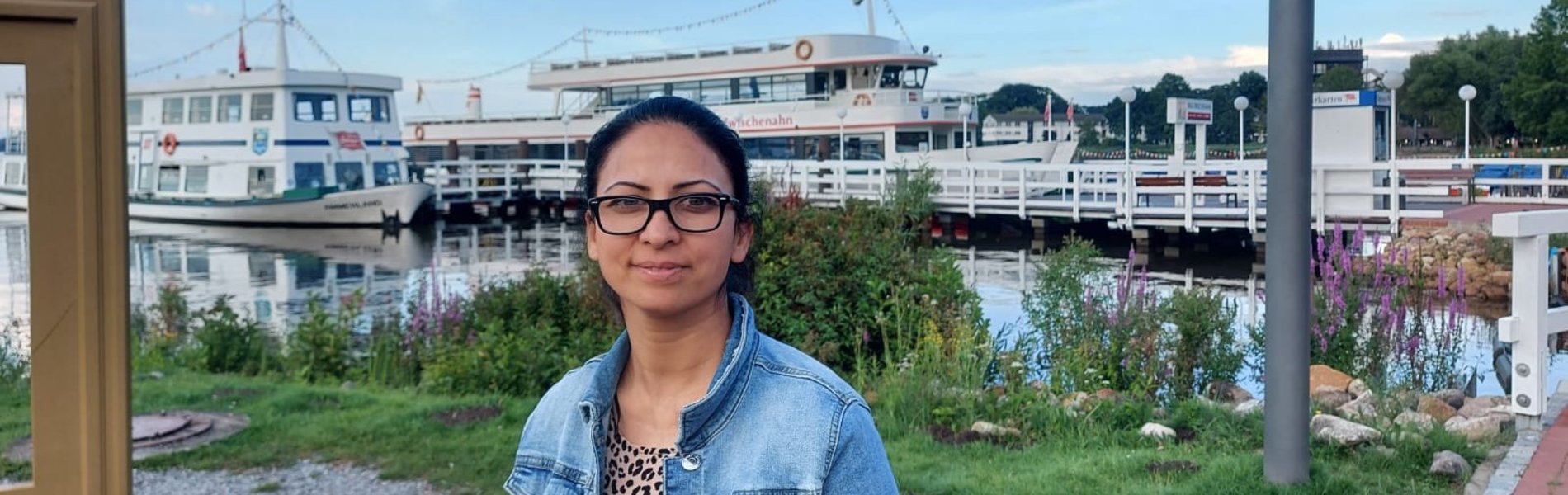 Eine junge Frau steh in einem Hafen.