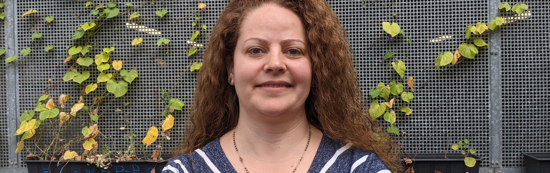 Eine Frau mit roten Haaren steht vor der Kamera.