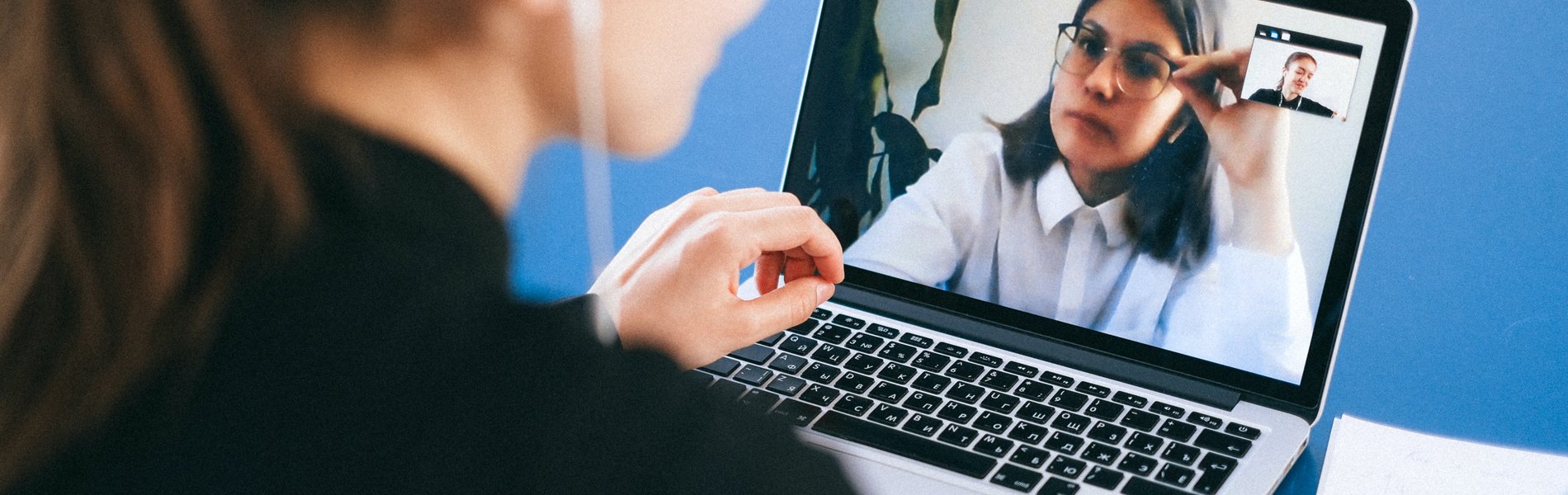 Eine Frau sitz an ihrem Laptop und hat einen Videocall.
