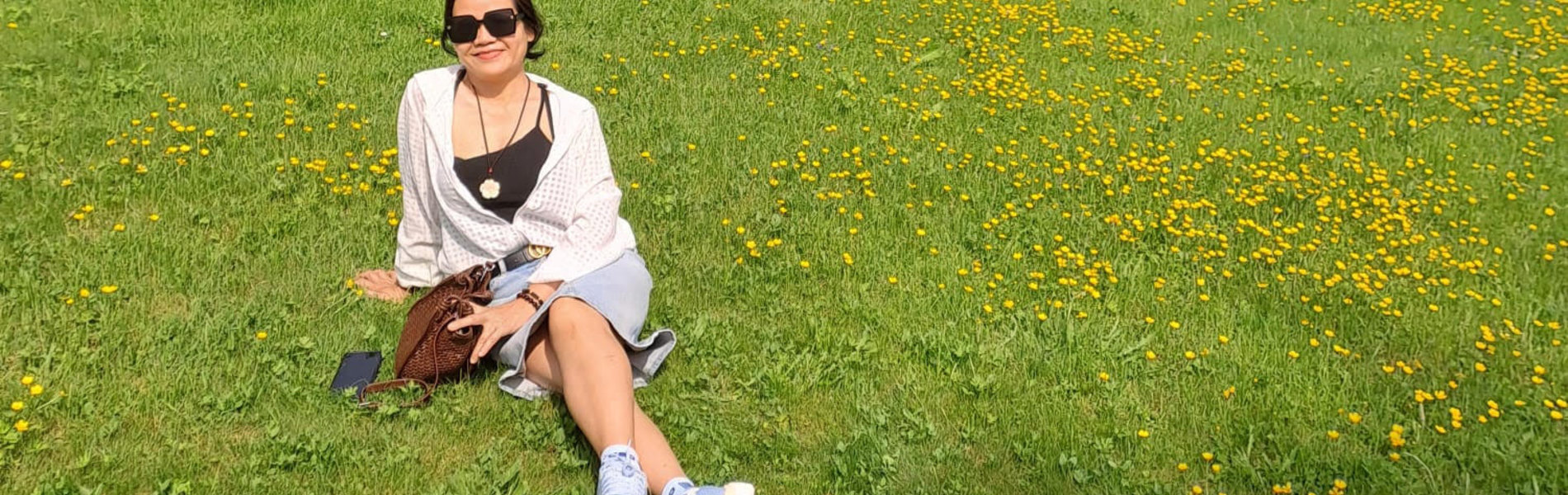 Eine Frau sitzt auf einer Wiese