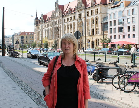 Eine junge Frau steht auf der Straße in Magdeburg.