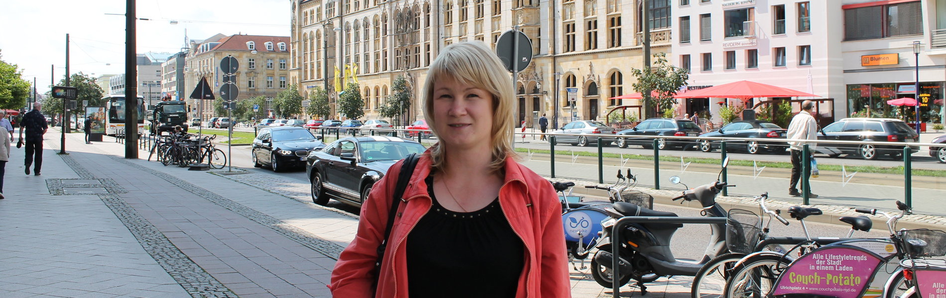 Eine junge Frau steht auf der Straße in Magdeburg.