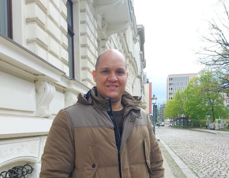 Ein großer, junger Mann steht auf der Straße.