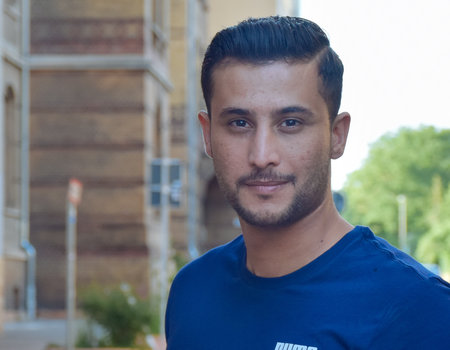 Ein junger Mann aus Syrien lächelt in die Kamera.