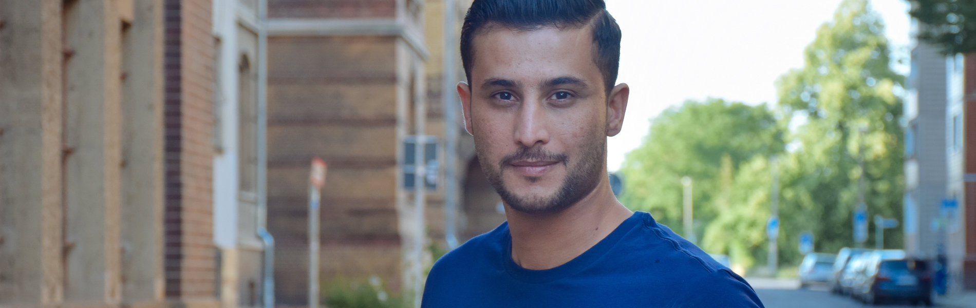Ein junger Mann aus Syrien lächelt in die Kamera.