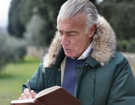 Ein älterer Mann liest in seinem Notizbuch