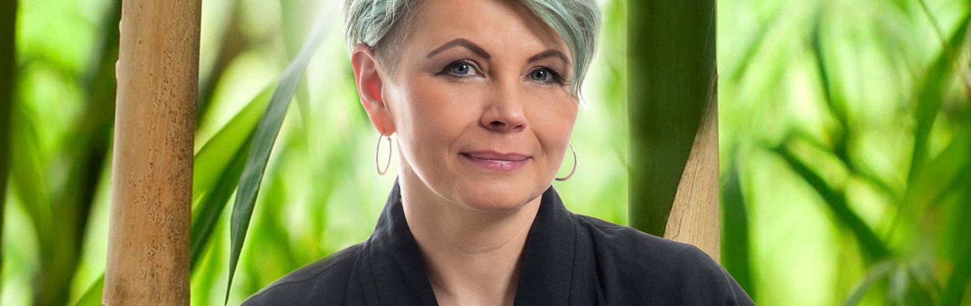 Eine blonde Frau sitzt im Schneidersitz.