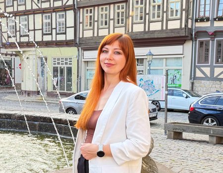 Eine Frau steht vor einem Brunnen