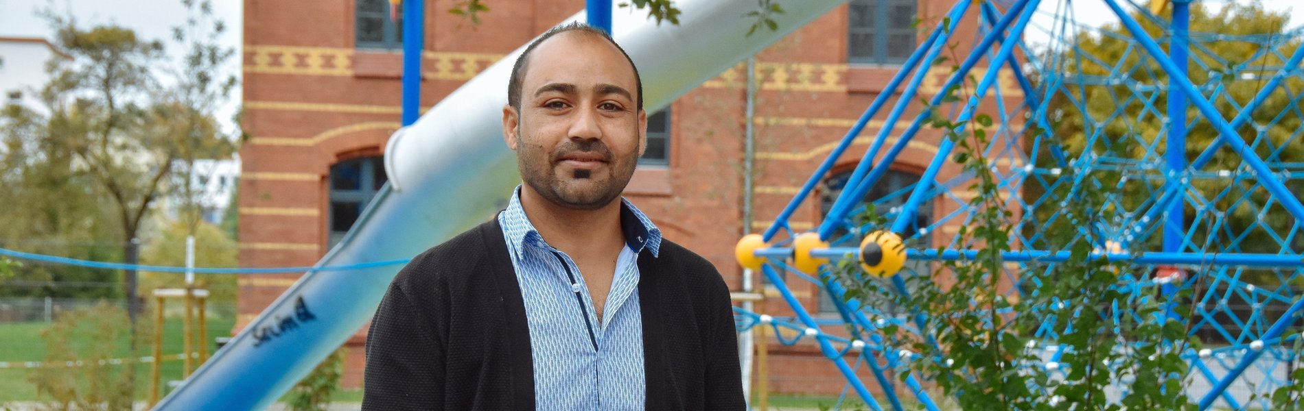 Ein junger Mann aus Syrien steht auf einem Spielplatz.