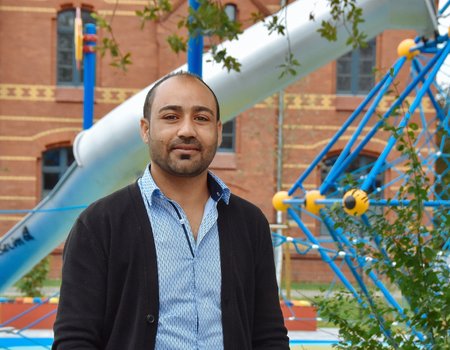 Ein junger Mann aus Syrien steht auf einem Spielplatz.