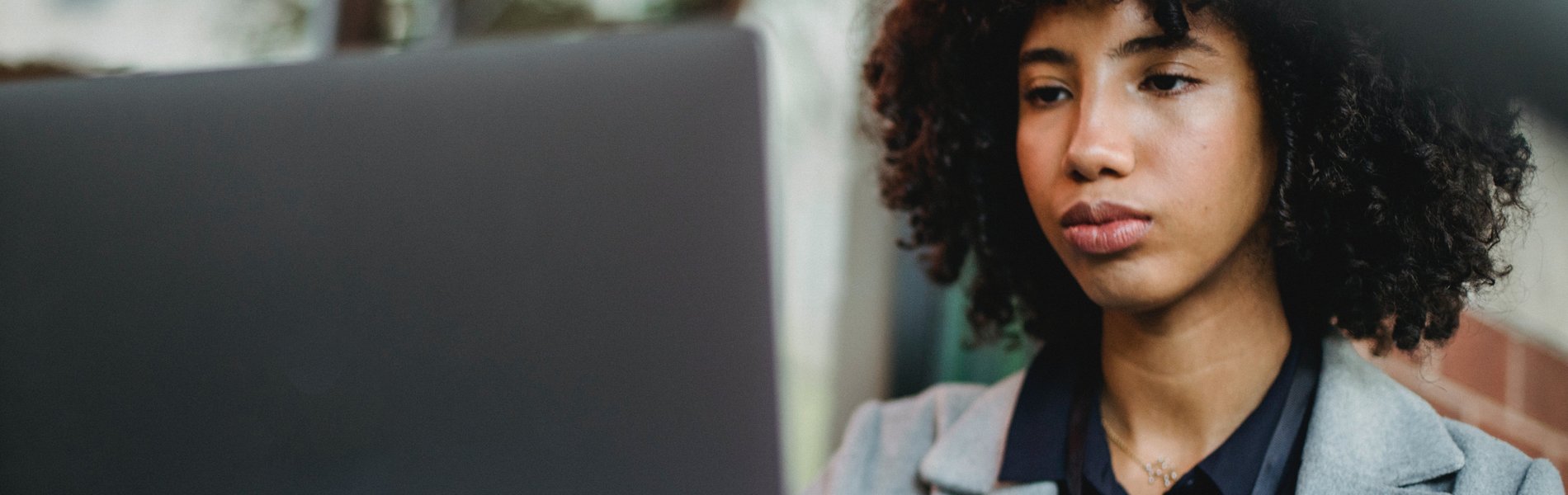 Eine migrantische Frau sitzt am Laptop