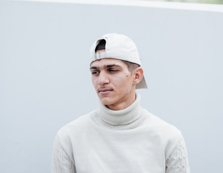 Ein junger Mann mit weißer Cap auf dem Kopf.